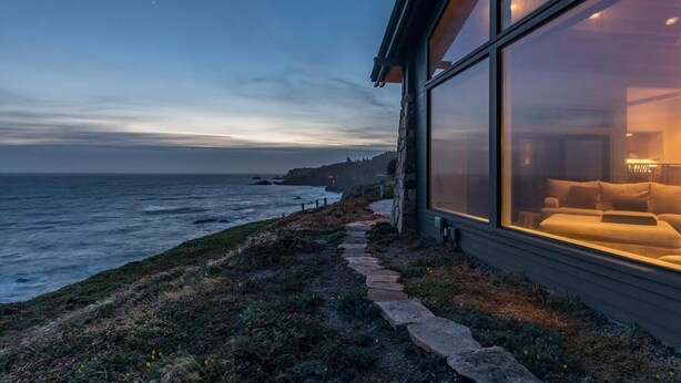 A modern house with large windows overlooking a coastal landscape. - Private, Oceanfront Views, Starlink WiFi, Timber Cove (Jenner)