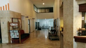 Un'ampia hall con soffitto alto, un'area salotto e a sfondo una lavanderia.