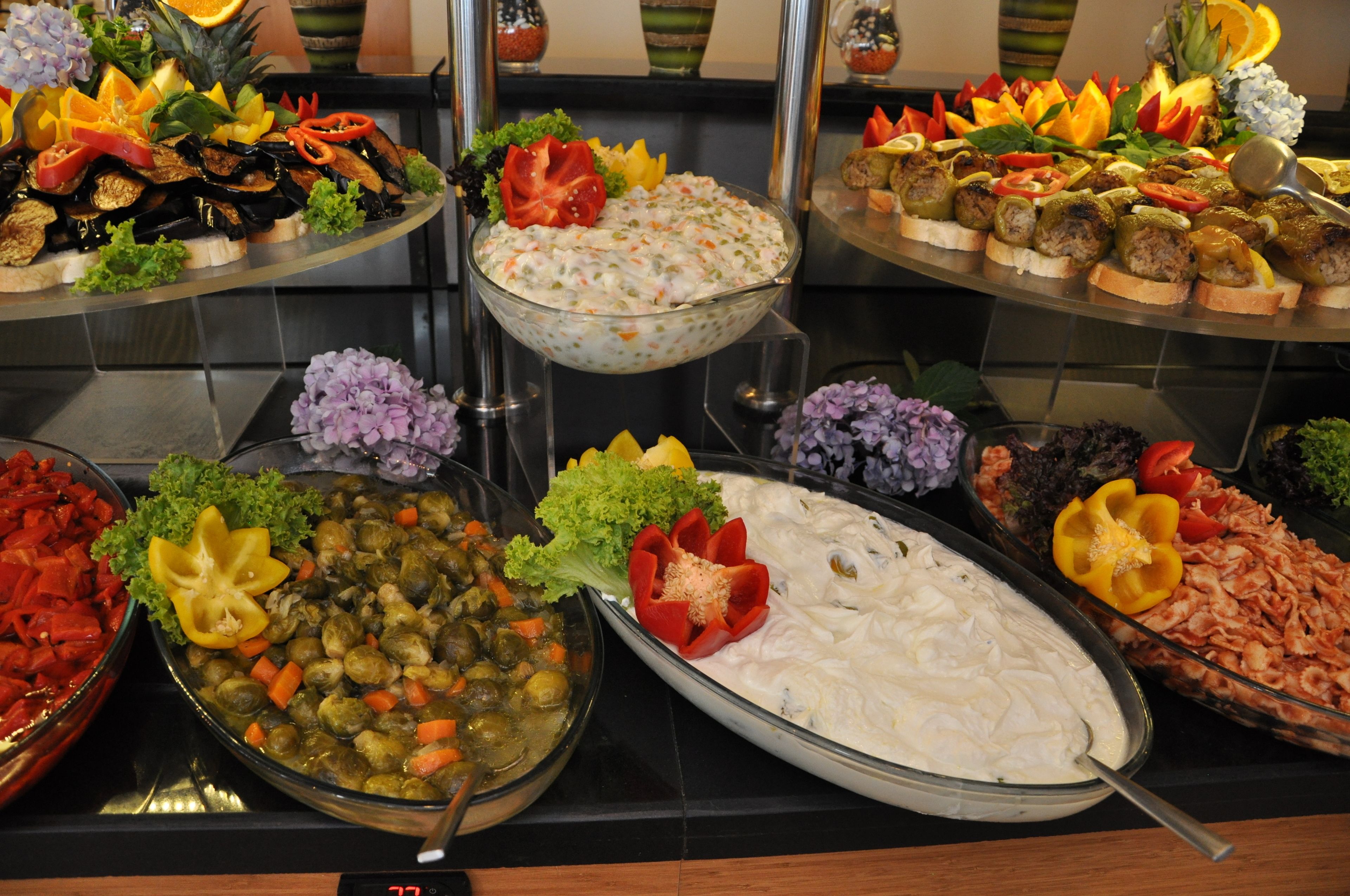 En buffet med et udvalg af retter, herunder salater, kød og grøntsager.