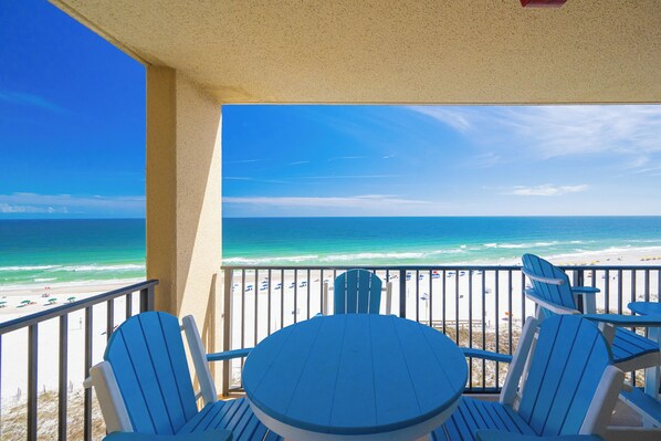 A balcony with a view of the beach and ocean.