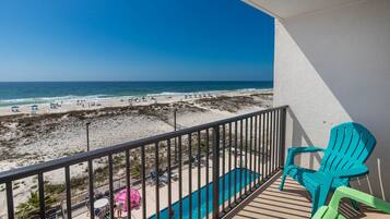 A balcony with a view of a beach and ocean.