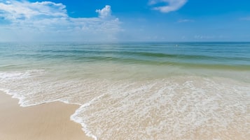 A beach with clear water and a sandy shore.