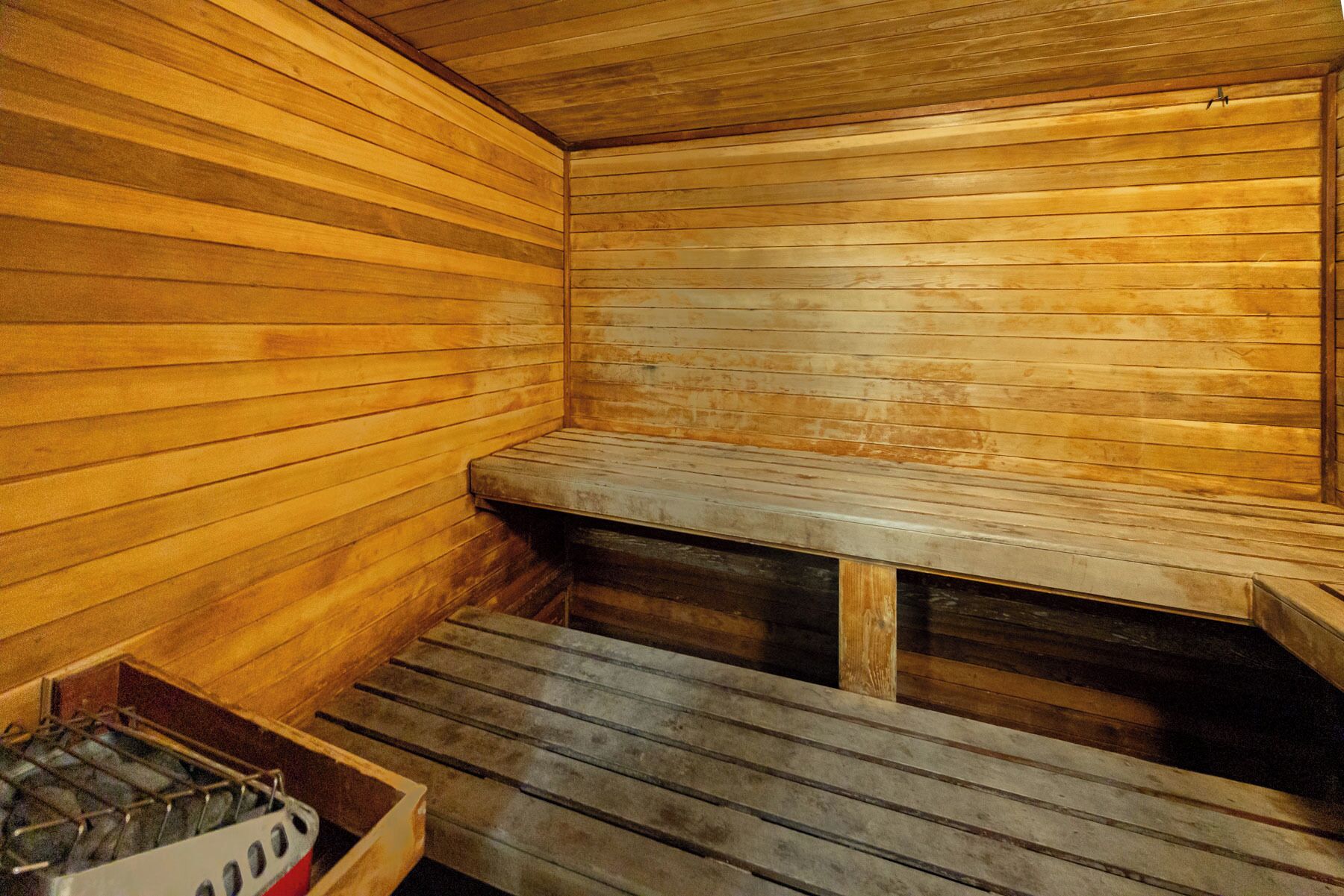 Eine Sauna mit Holzbänken und einer Sitzbank.