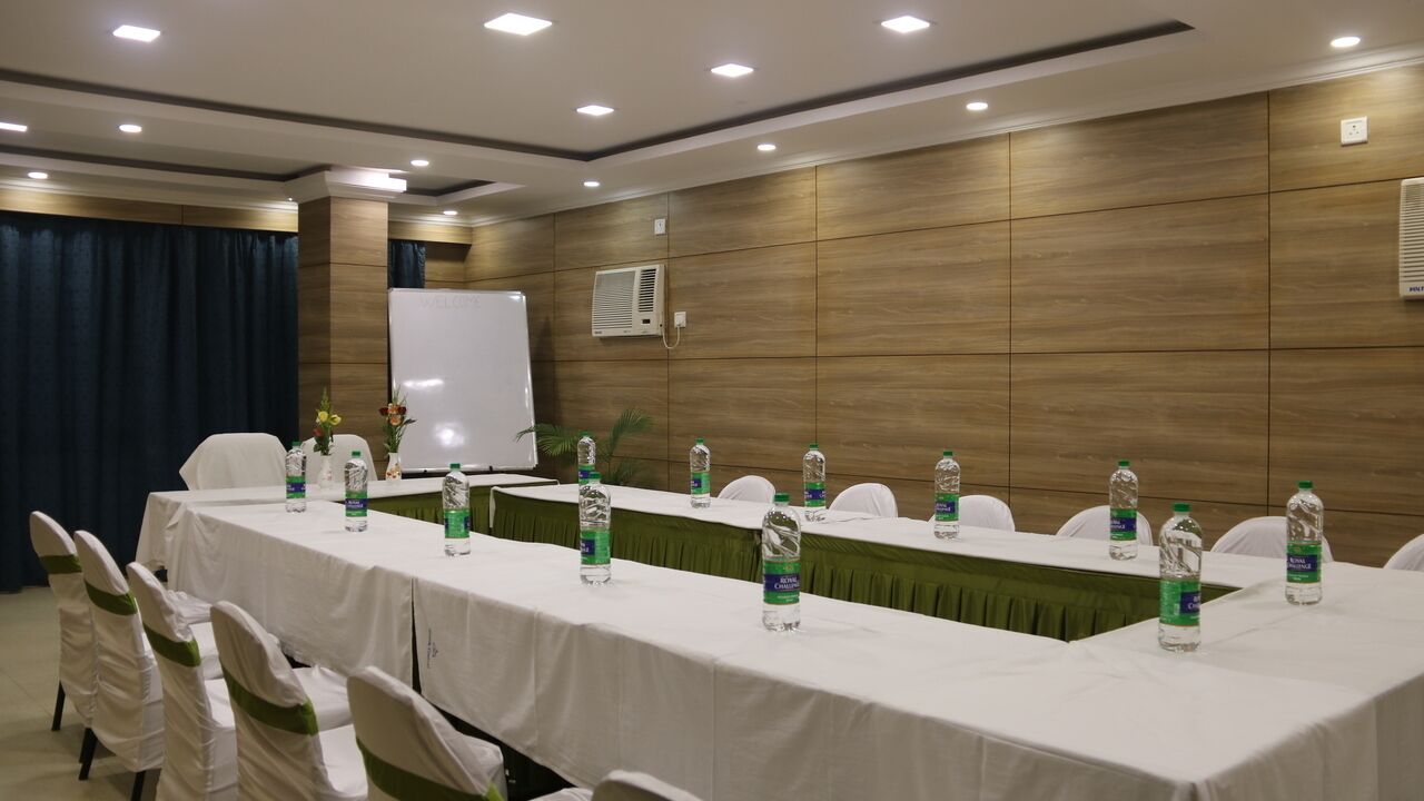 A conference room with a long table, white chairs, and water bottles.