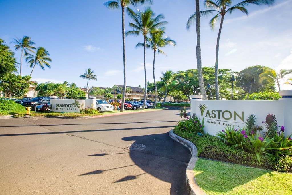 A parking lot with signs for 'Islander The Beach' and 'Vaston Hotels & Resorts'.