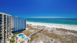 A high-rise hotel with a beach view, a pool area, and a boardwalk leading to the beach. - Phoenix VII 71414 Gulf-Front Orange Beach Condo (Orange Beach)
