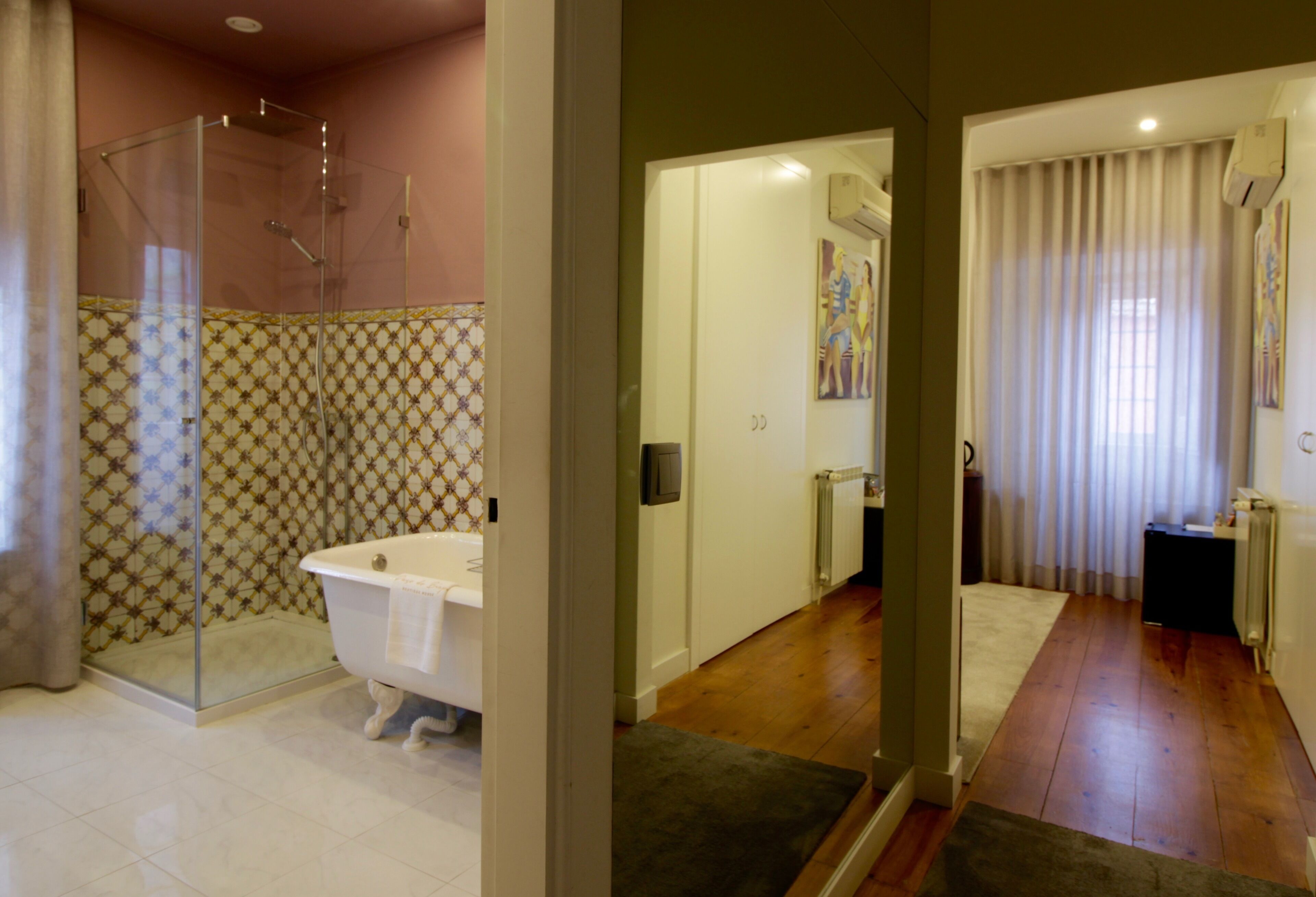 Une salle de bain moderne avec une douche à l’italienne en verre, une baignoire blanche et des carreaux à motifs.