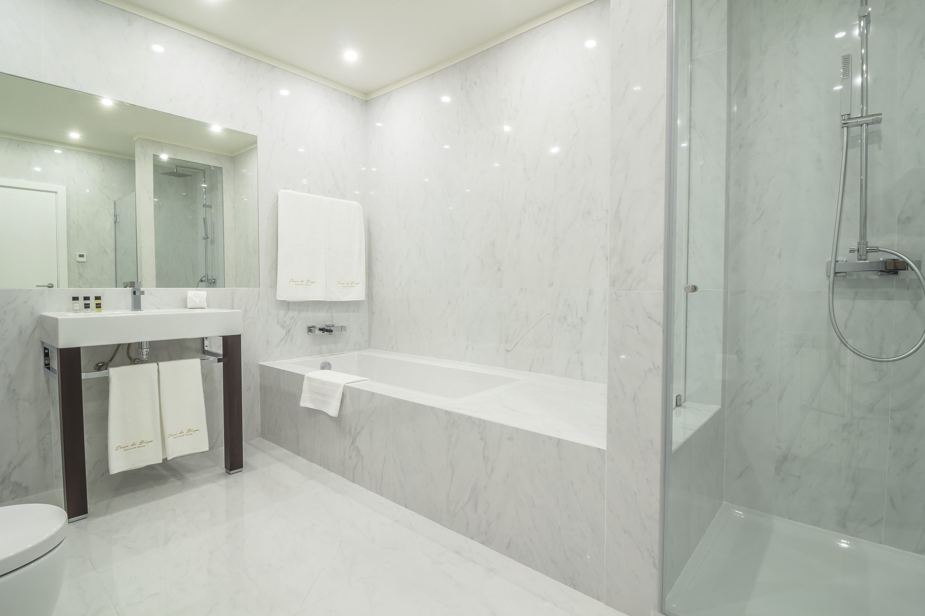 Une salle de bain moderne dotée d’une douche à parois de verre, d’une baignoire sur pieds et d’un meuble-lavabo avec un miroir.