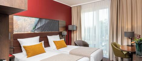Une chambre d’hôtel avec deux lits, un bureau, une chaise et une grande fenêtre avec des rideaux.