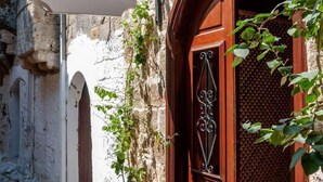 A narrow street with a wooden door and a sign reading "Auberge 32". - Auberge 32 | Old Town (Rhodes)