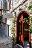 Egy keskeny utca, rajta egy fa ajtó és egy „Auberge 32” feliratú tábla.