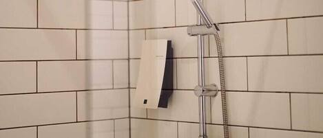 A shower with a handheld showerhead and a handheld shower attachment, mounted on a tiled wall.