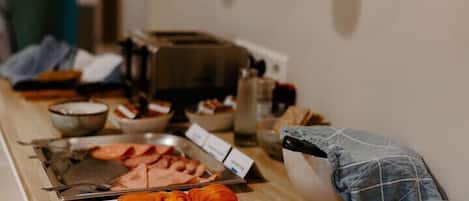 Una mesa de madera con varios alimentos y utensilios para un bufé.