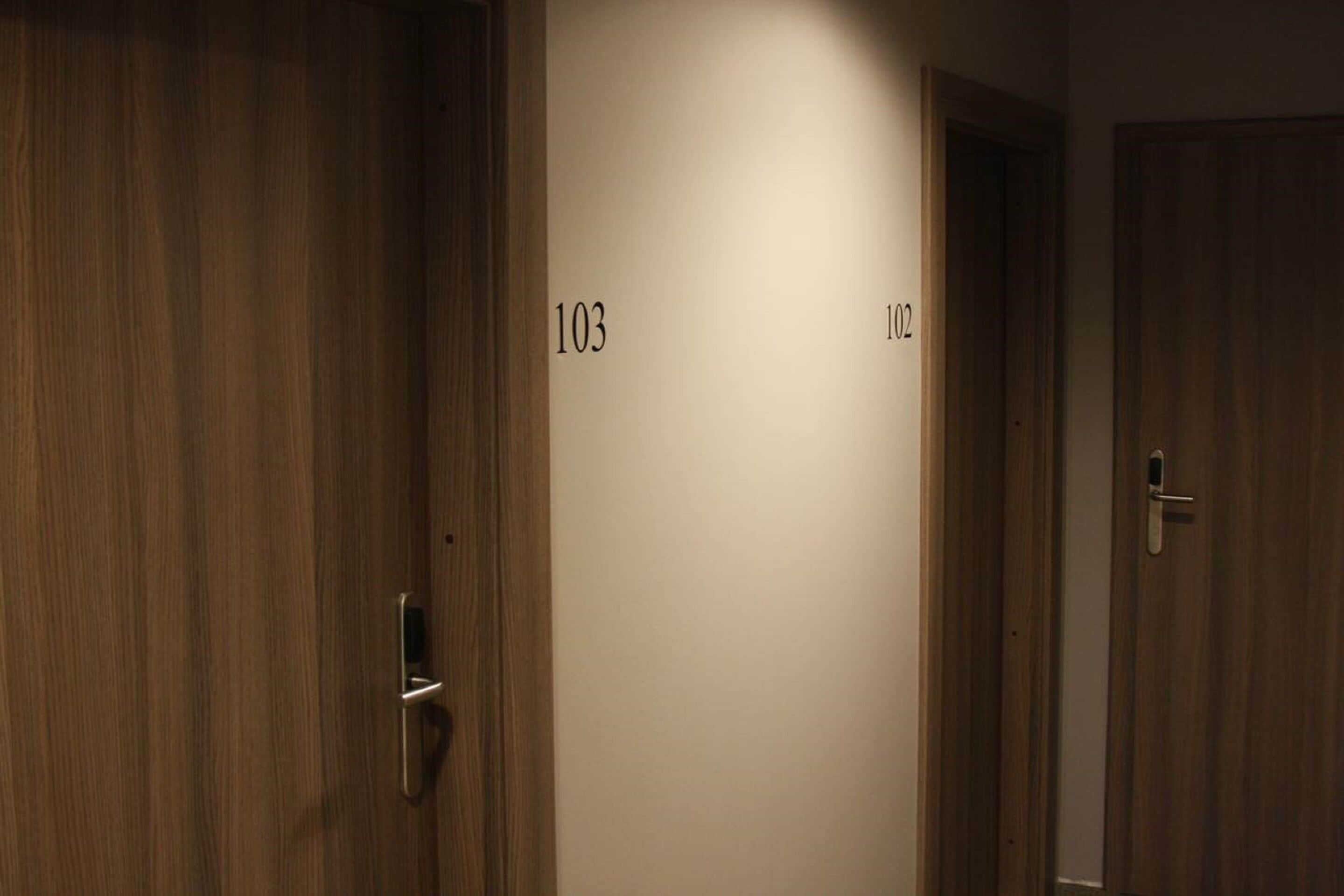 A hallway with wooden doors numbered 103 and 102.