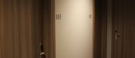 A hallway with wooden doors numbered 103 and 102.