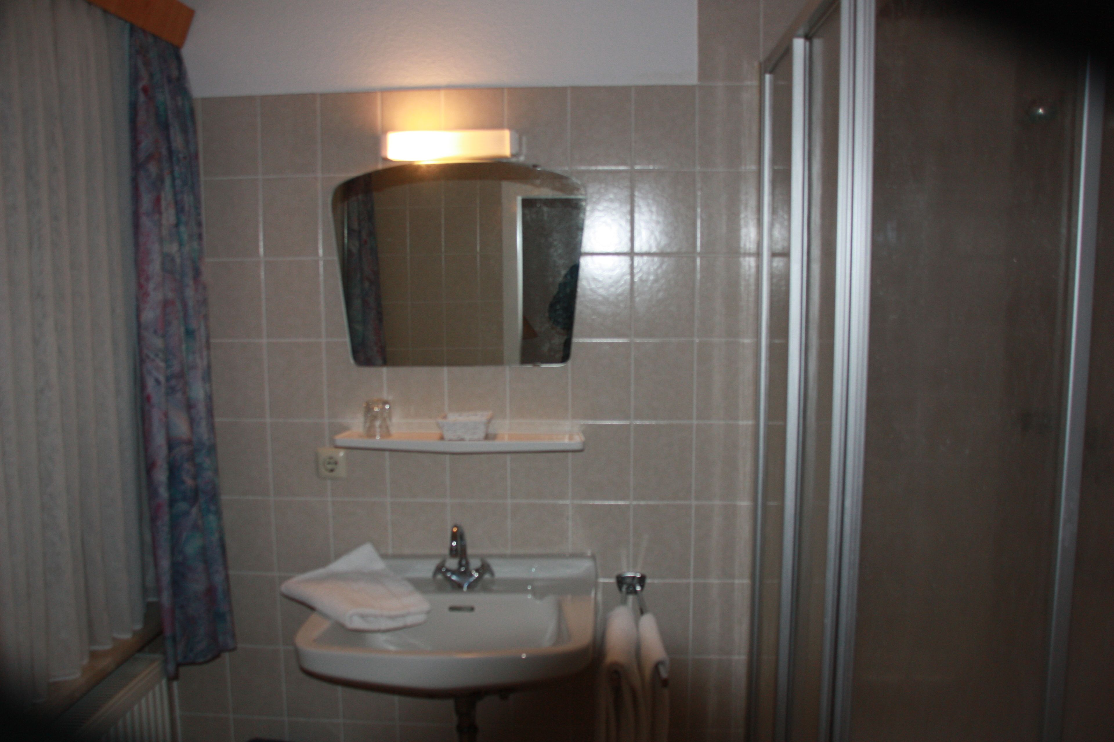 A bathroom with a sink, mirror, and towel rack.