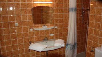 A bathroom with a sink, mirror, and shower curtain.