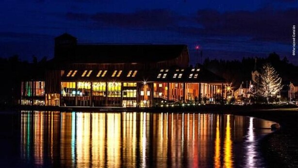 A waterfront hotel with a reflective pool in front. - Hotel Frutillar (Frutillar)