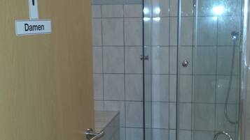 A bathroom with a shower, toilet, and sink.