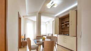 Una sala de estar moderna con comedor, piso de madera y armarios de cocina empotrados.