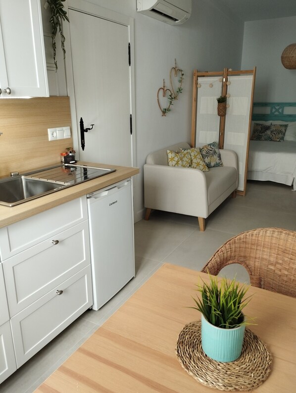 A compact kitchen with a sink, a small refrigerator, and a wooden countertop. - Apartamento Casa Eva (Nerja)