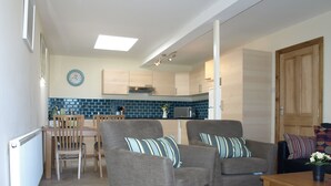 Un espacio habitable compacto con comedor, cocina y zona de estar.