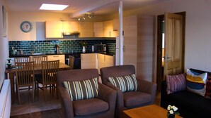 Un espacio habitable compacto con comedor, kitchenette y zona de estar.