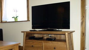 Un mueble de madera con un centro de entretenimiento que incluye un televisor de pantalla plana, un reproductor de DVD y un control remoto.