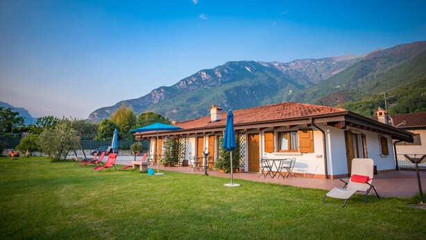 Eine Villa mit Terrasse, Sitzgelegenheiten im Freien und Bergblick.