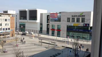 Una calle urbana moderna con edificios comerciales, incluyendo Subway y K&L.