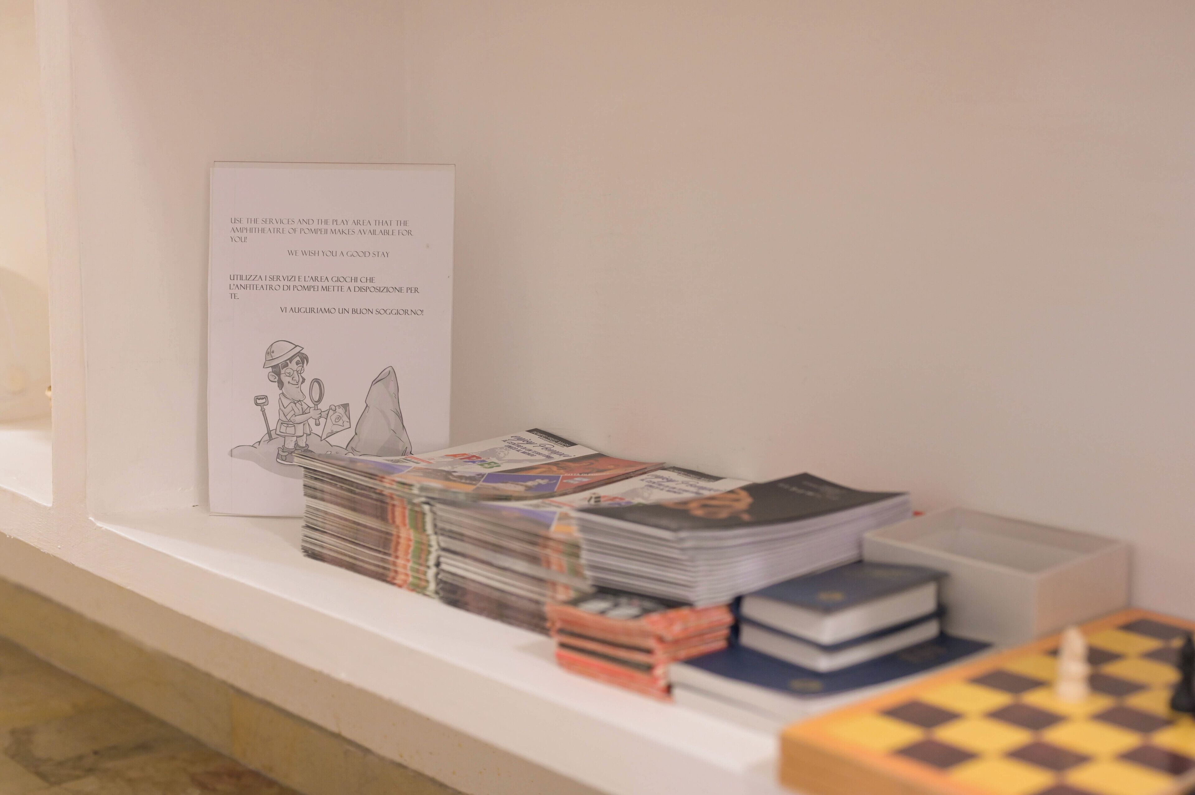 A display with a sign, magazines, and a chessboard.