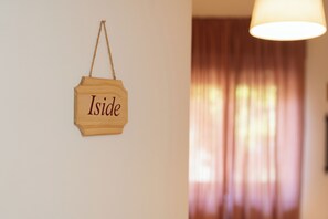 A wooden sign with the word "Iside" hanging on a wall. - L'anfiteatro di Pompei B&B (Pompei)