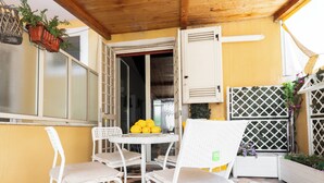 A patio with white chairs, a table with a fruit bowl, and potted plants. - L'anfiteatro di Pompei B&B (Pompei)