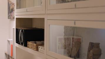 A display of various items including books, a black refrigerator, and framed artwork on shelves.