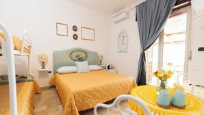 A hotel room with a bed, a small table with a vase of flowers, and a window with curtains. - L'anfiteatro di Pompei B&B (Pompei)