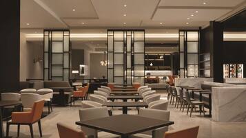 A modern restaurant with a central dining area, high ceilings, and a kitchen in the background.
