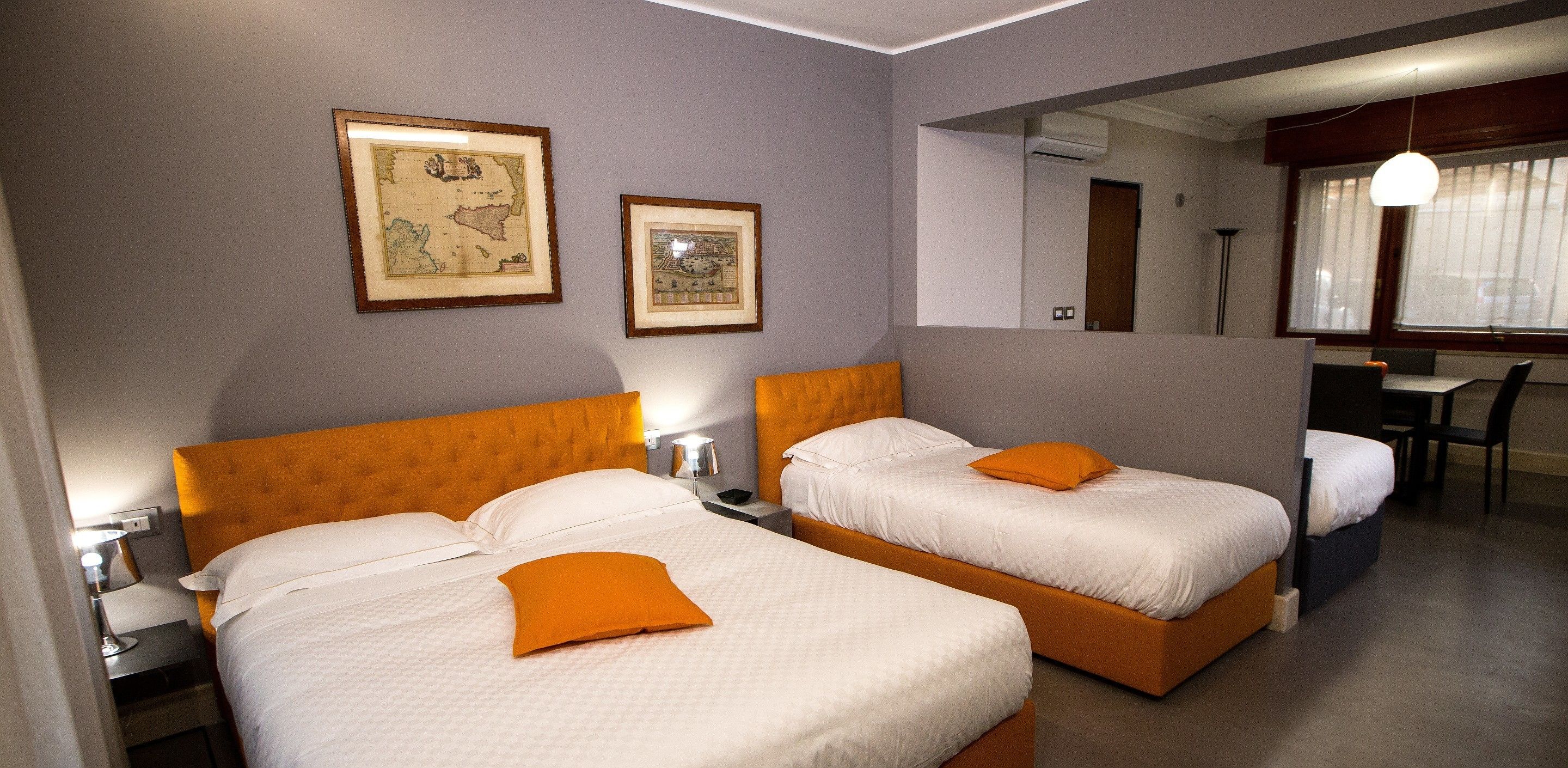 A hotel room with two beds, a desk, and a chair.