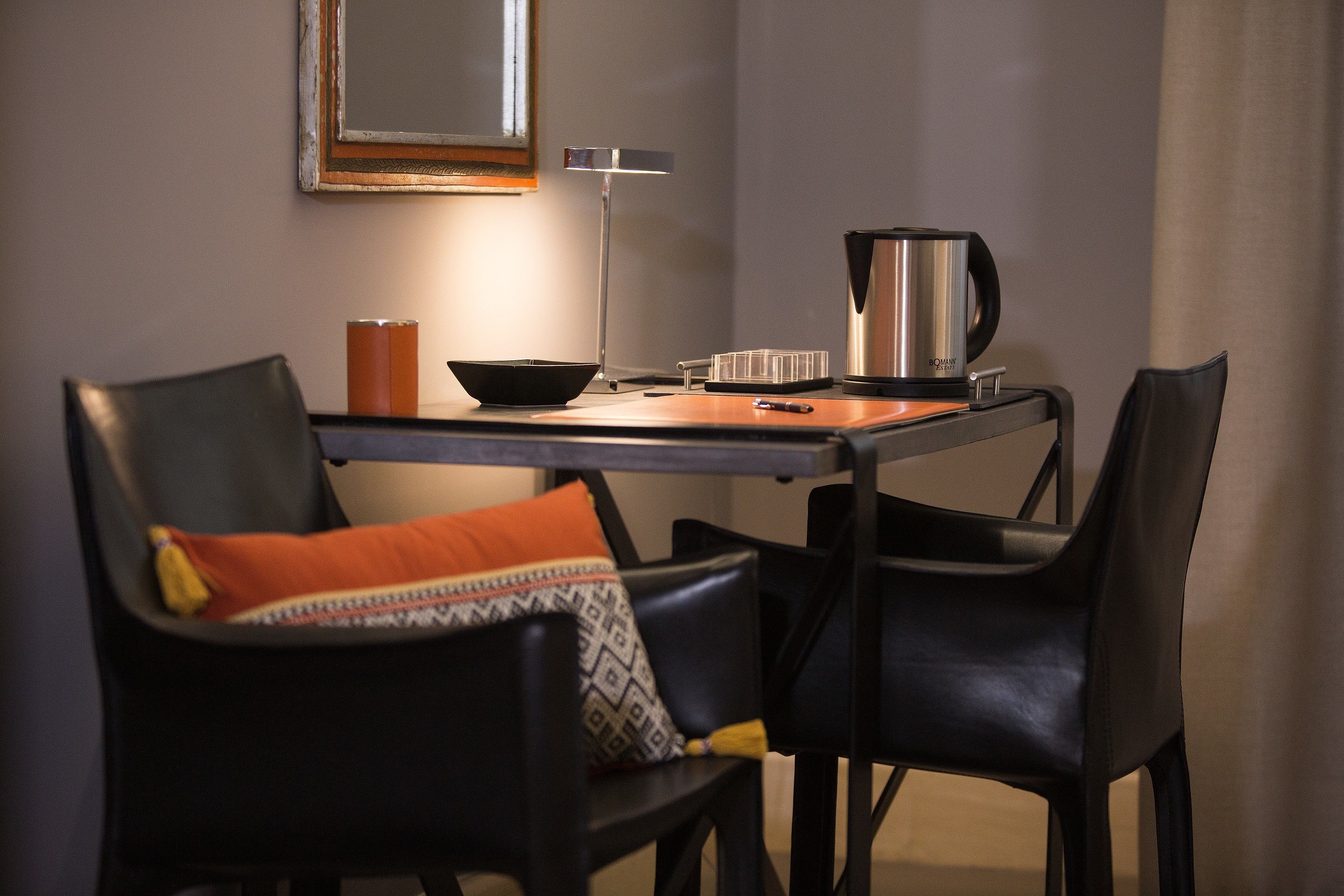 Ein Essbereich mit Tisch, Stühlen, einer Kaffeemaschine und einer Lampe.