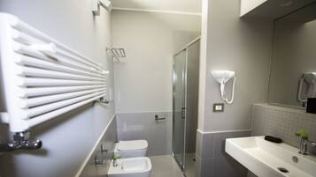 Une salle de bain moderne avec une douche à parois de verre, un lavabo blanc et un porte-serviettes.