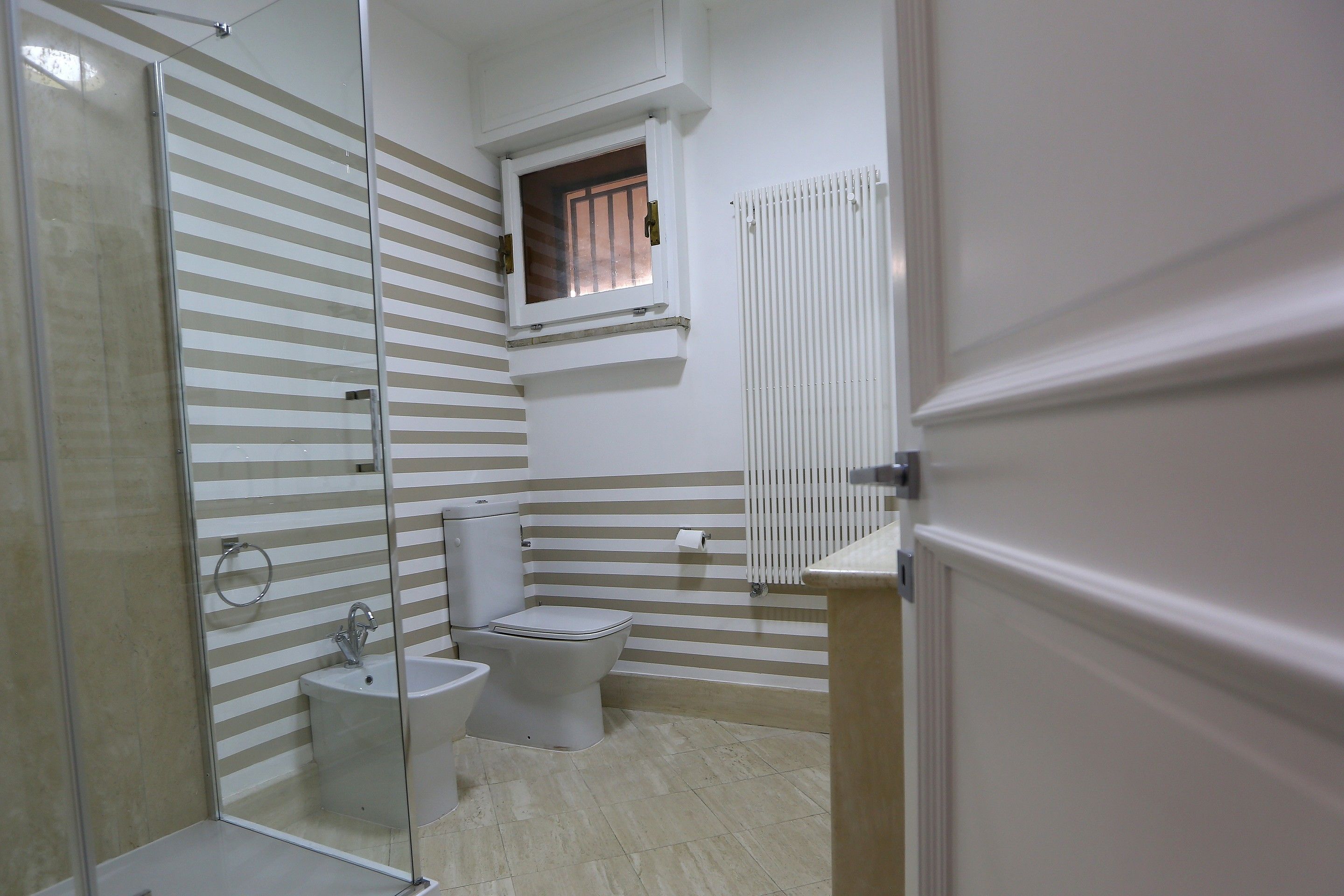 Une salle de bain avec douche, toilettes et lavabo.