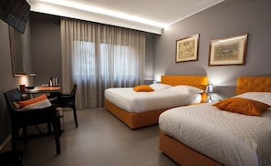 A hotel room with two beds, a desk, and a chair. - Principessa Mafalda (Messina)