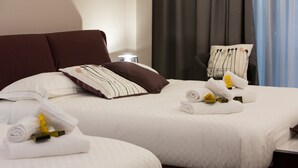 A hotel room with two beds, each with white linens and brown headboards. There are towels and toiletries on the beds. - Principessa Mafalda (Messina)