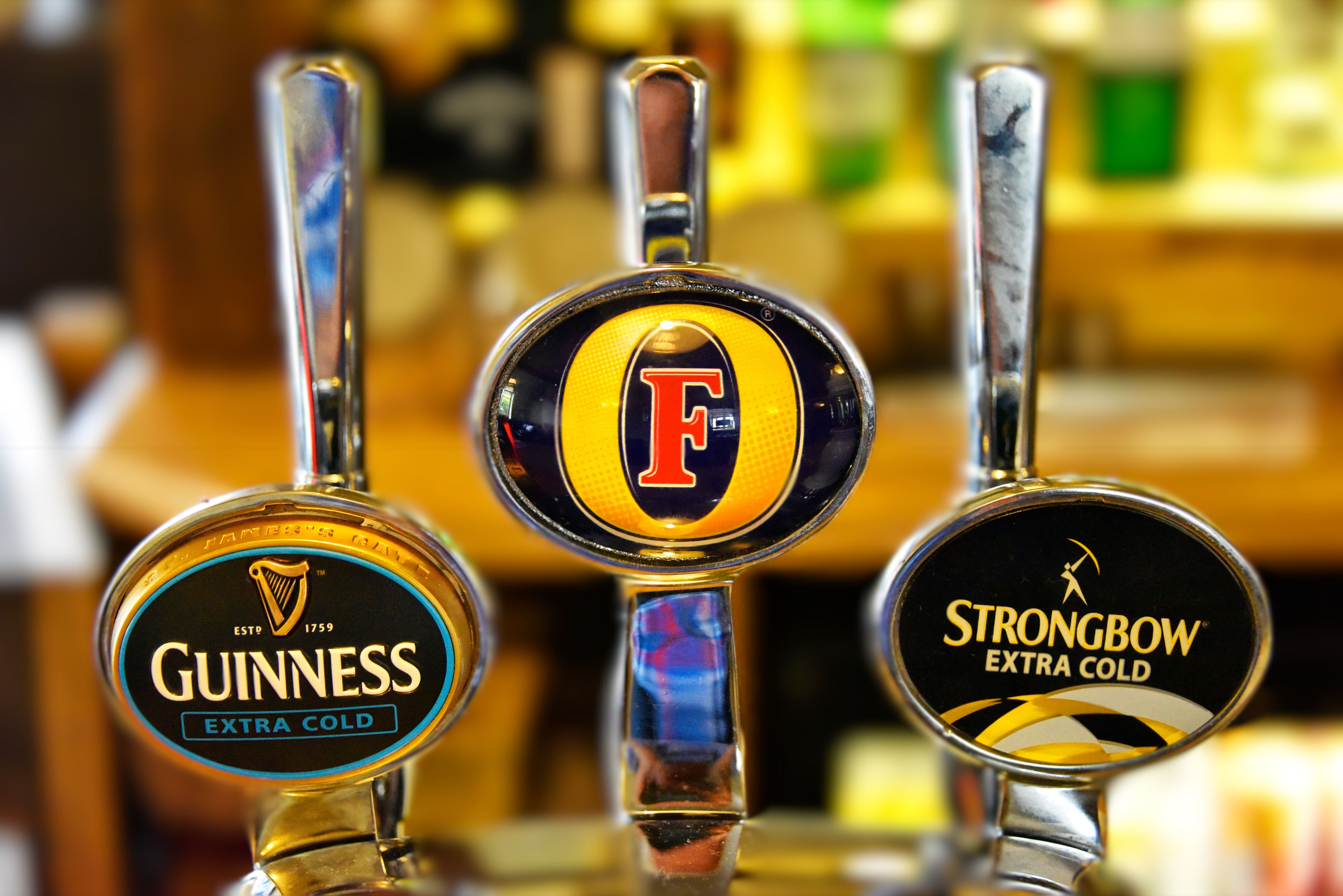Tre ölfatkranar märkta med Guinness, F och Strongbow Extra Cold.