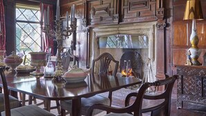 Ein Esszimmer mit Holztisch, Stühlen und Kamin.