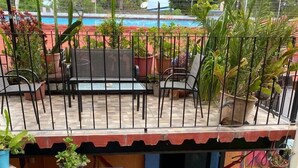 A multi-level outdoor area with potted plants, a pool, and outdoor seating.