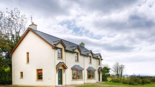A two-story house with a gabled roof, a front entrance, and a driveway. - Ballylickey Bay Holiday Home (Bantry)