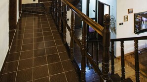 A wooden staircase with a handrail leading to an upper floor. The floor is tiled with a geometric pattern. - Yaprak Dag Evi (Sapanca)