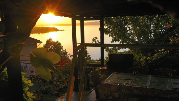 A patio with a table and chairs, overlooking a body of water during sunset. - Yaprak Dag Evi (Sapanca)