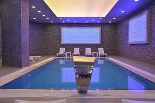 Una piscina techada, sillones reclinables de piscina