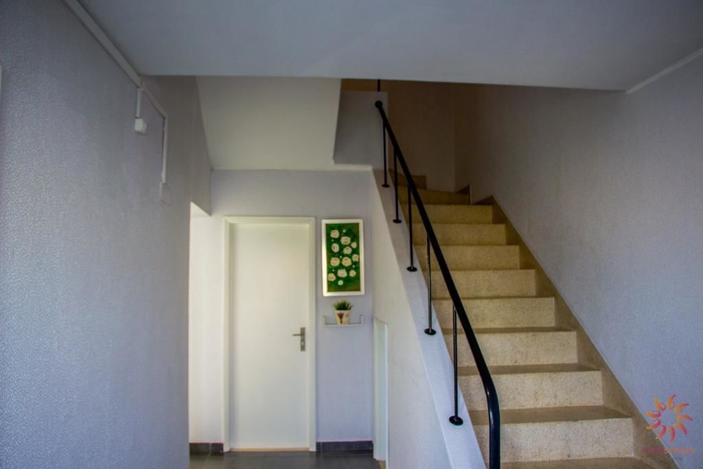 A staircase with a handrail leading to a landing.